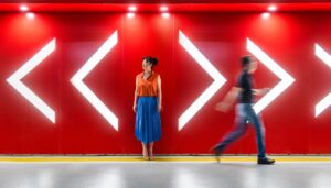 Woman standing against a red background with arrows