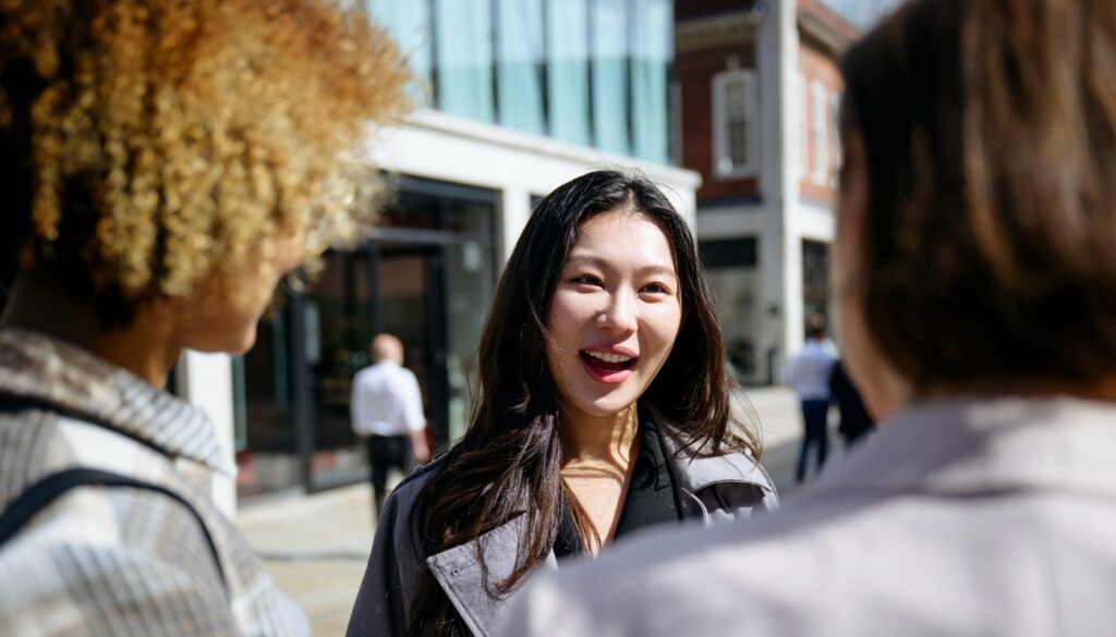 Three people standing outside an office building in conversation