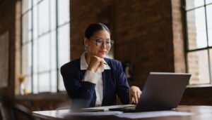 Woman of Asian descent sitting at her laptop.