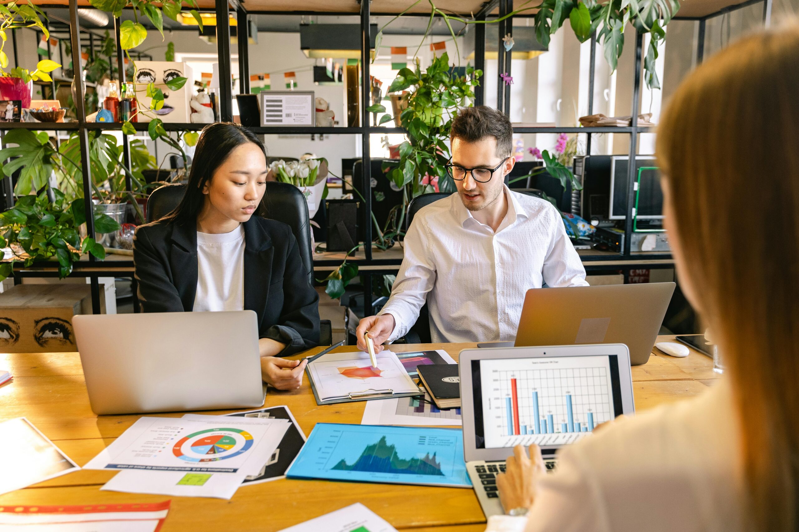 Collaborative data presentation meeting with a young woman and man looking at data on a piece of paper